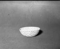 Mrs. Donald Segerstrom Collection. Object: Miwok basket. Dimensions: 7 1/2 x 2-3/4". Materials: Bracken fern root, heavy grass bundle foundation, split shoot. Technology: Clockspring start with culls extending 1 1/2" diameter as foundation, overstitched rim slanting leftward, fag ends trimmed on work face, moving ends trimmed on interior. Photographed by Michael Dixon. Catalogued by Craig Bates and Barbara Beroza. Yosemite Collections, National Park Service. 1/83.