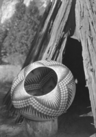 Lucy Telles' largest basket completed in 1933. Squares are reddish, the points are black. The background is tan and light brown.