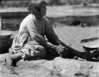 Maggie pounding acorns. Baskets in Yosemite Museum.