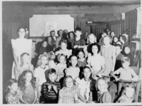 Shirley Temple's birthday party at the Ranger's Club. Local children: 1st row, 5th from left - Norma Jean Sprinkle. 2nd row, 4th from left - Elaine Sprinkle. 3rd row, far left, standing - Charlotte Ewing (Wilson). Shirley Temple sitting to the left of the rocking chair.