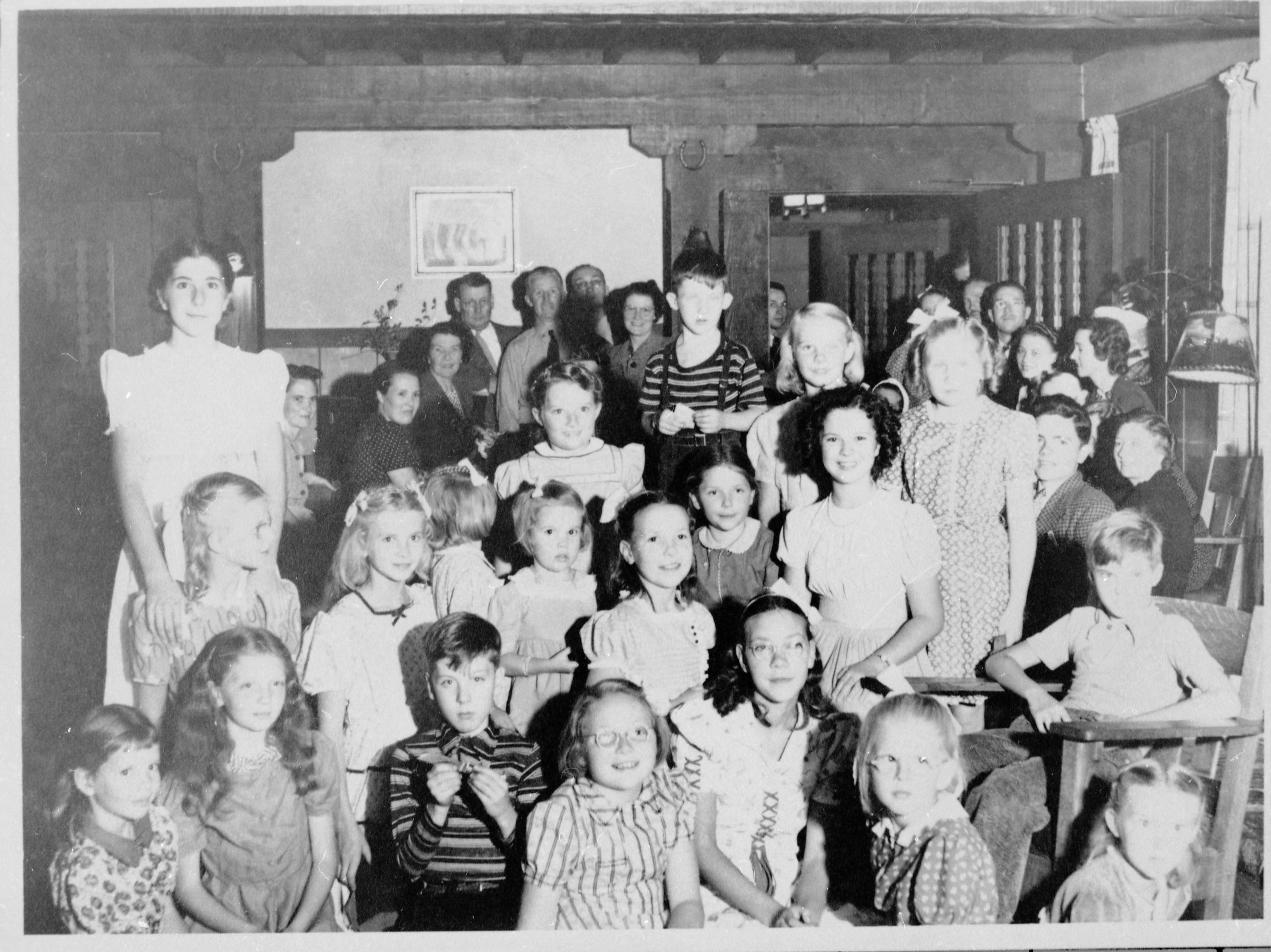 Shirley Temple's birthday party at the Ranger's Club. Local children: 1st row, 5th from left - Norma Jean Sprinkle. 2nd row, 4th from left - Elaine Sprinkle. 3rd row, far left, standing - Charlotte Ewing (Wilson). Shirley Temple sitting to the left of the rocking chair.