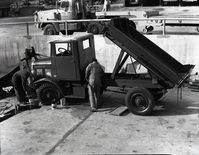 Painting FWD snow plow in maintenance area.