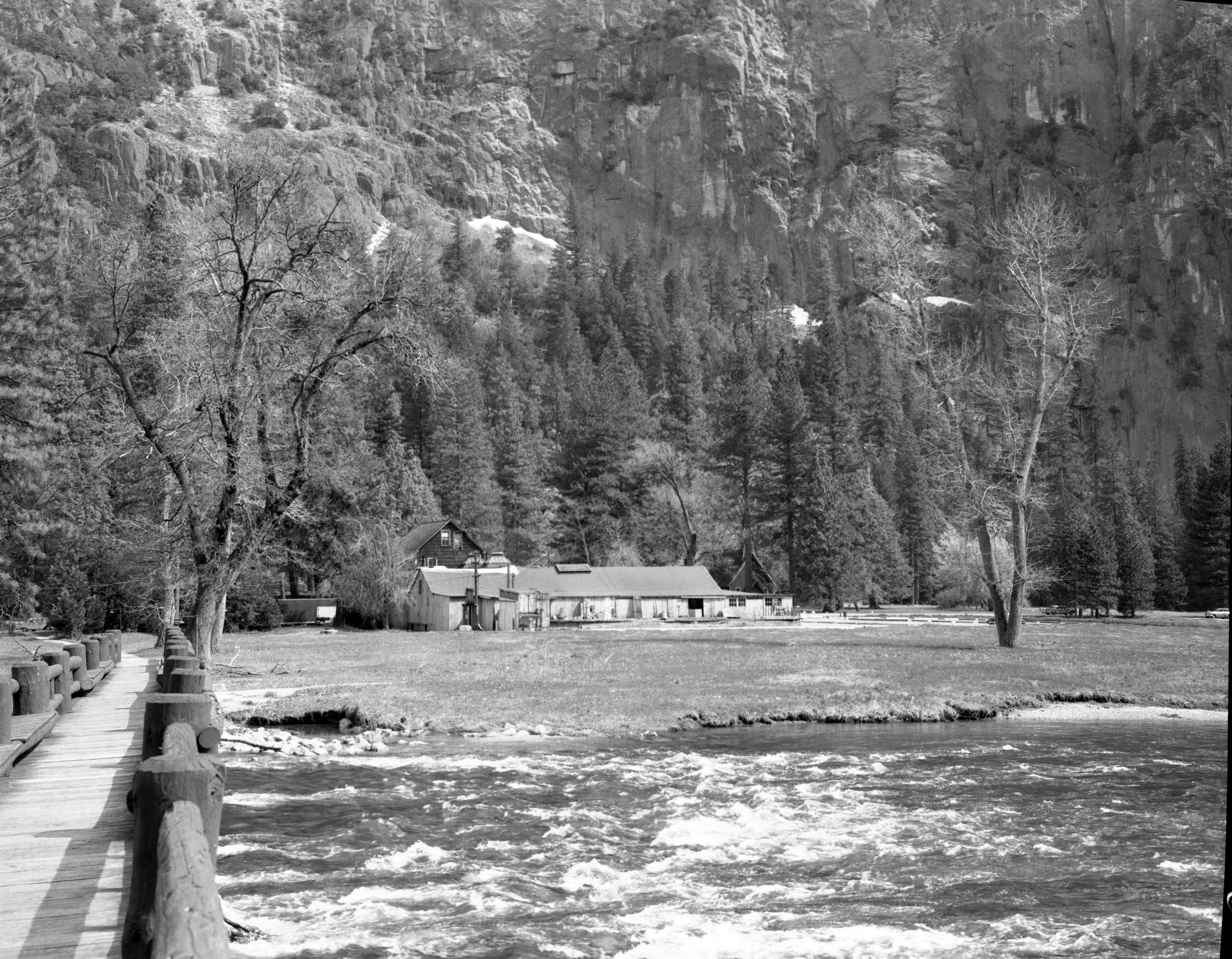 Store in Old Village from Supt.'s bridge. "View of structures to be eradicated under mission 66 in Yosemite" Before image.