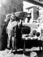 Alice (Tom) James Wilson, at the opening of the Ahwahnee Hotel poised with a variety of Mono Paiute & Washoe Baskets, wearing an "Indian Style" dress of her own making. Copied by Michael Dixon, Nov. 1980.