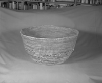 Private Collection. Object: Miwok basket. Dimensions: 18 x 10". Materials: Redbud and split willow shoots in original basket. Repairs in split maple shoots. Technology: Original basket is single rod, interlocking stitch, leftward coil direction. Repair begun on base of old basket and worked toward center until center 3 1/4", when clockspring start was stitched in to fill remainder two rows of coiling with two sewing strands at the same time, one redbud & one willow, near upper edge of original basket. Collection History: Collected by owner's mother. Murphys 1915. Photographed by Michael Dixon. Catalogued by Craig Bates and Barbara Beroza. Yosemite Collections, National Park Service.