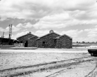 East elevation of new Tribal and National Park Service Visitor Center at the time of the dedication and 50th anniversary of Pipe Spring National Monument. Rows of chairs for ceremony set up on south side of building.