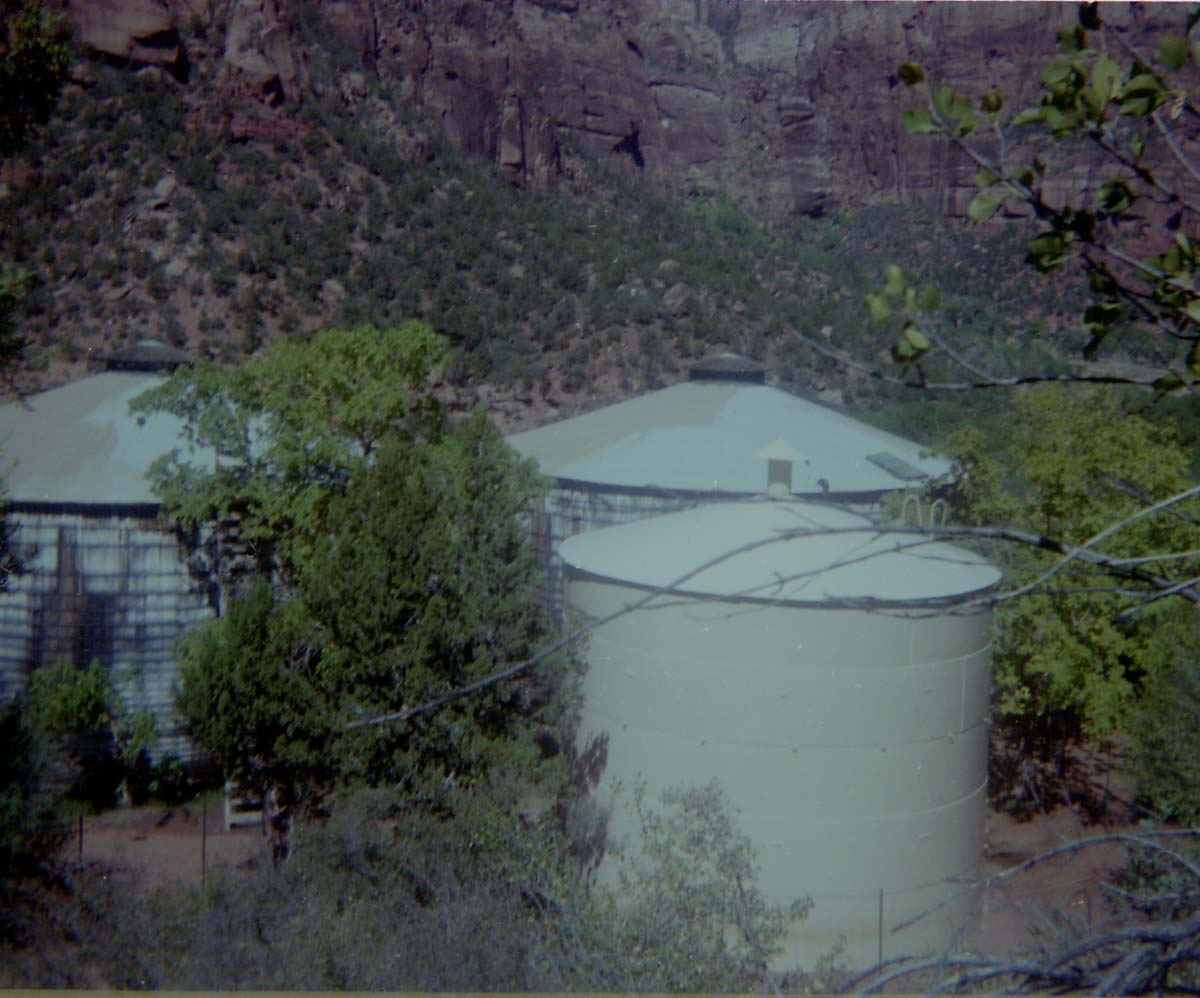 Three water tanks with new paint applied during reroofing project.