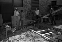 Workers laying cement during the construction of the headquarters addition.