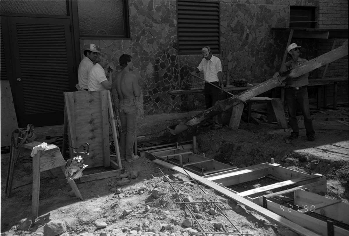 Workers laying cement during the construction of the headquarters addition.