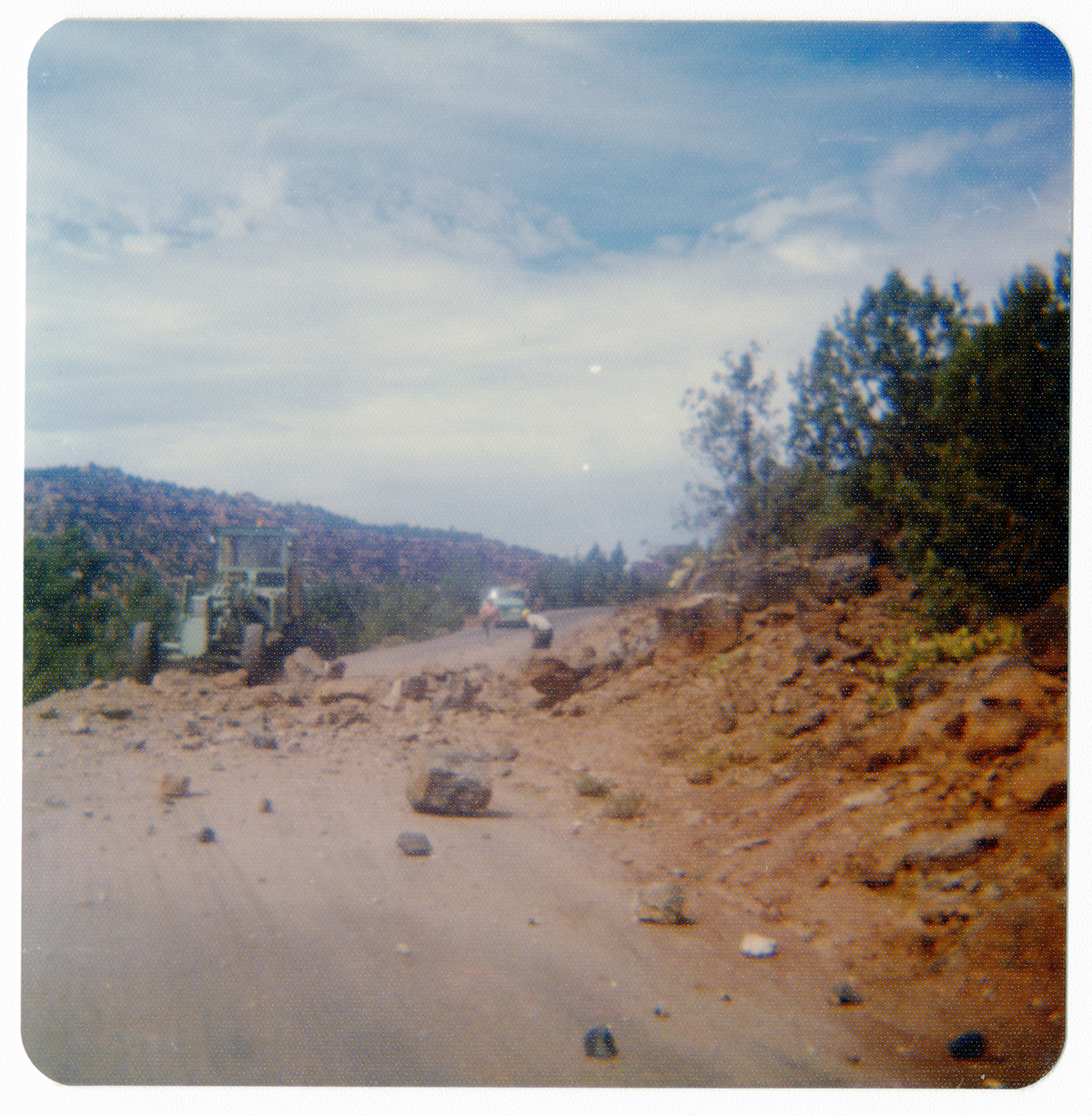 Rock pile across road with men working to clear it along the Kolob Terrace Road.