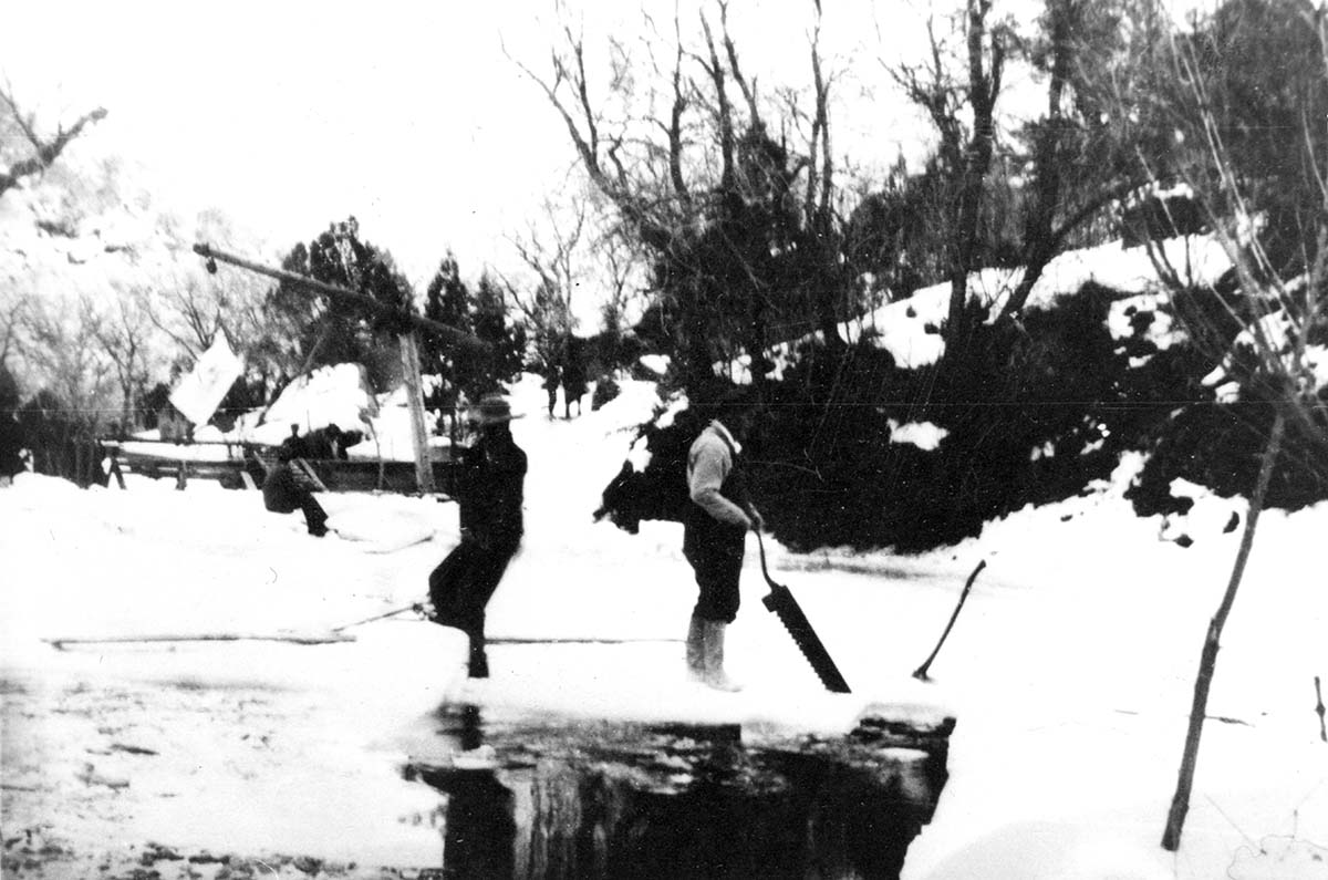 Freeborn Gifford and Lloyd Crawford harvesting/cutting ice in Oak Creek Canyon. Three of Freeborn Gifford's boys in the background.