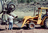 Workers operating construction vehicles during the construction of headquarters addition.