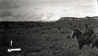 Man on horse in a field of sage and scrub brush named 'hog heaven'. [Appears to be on the Kolob Terrace near Cave Valley?]