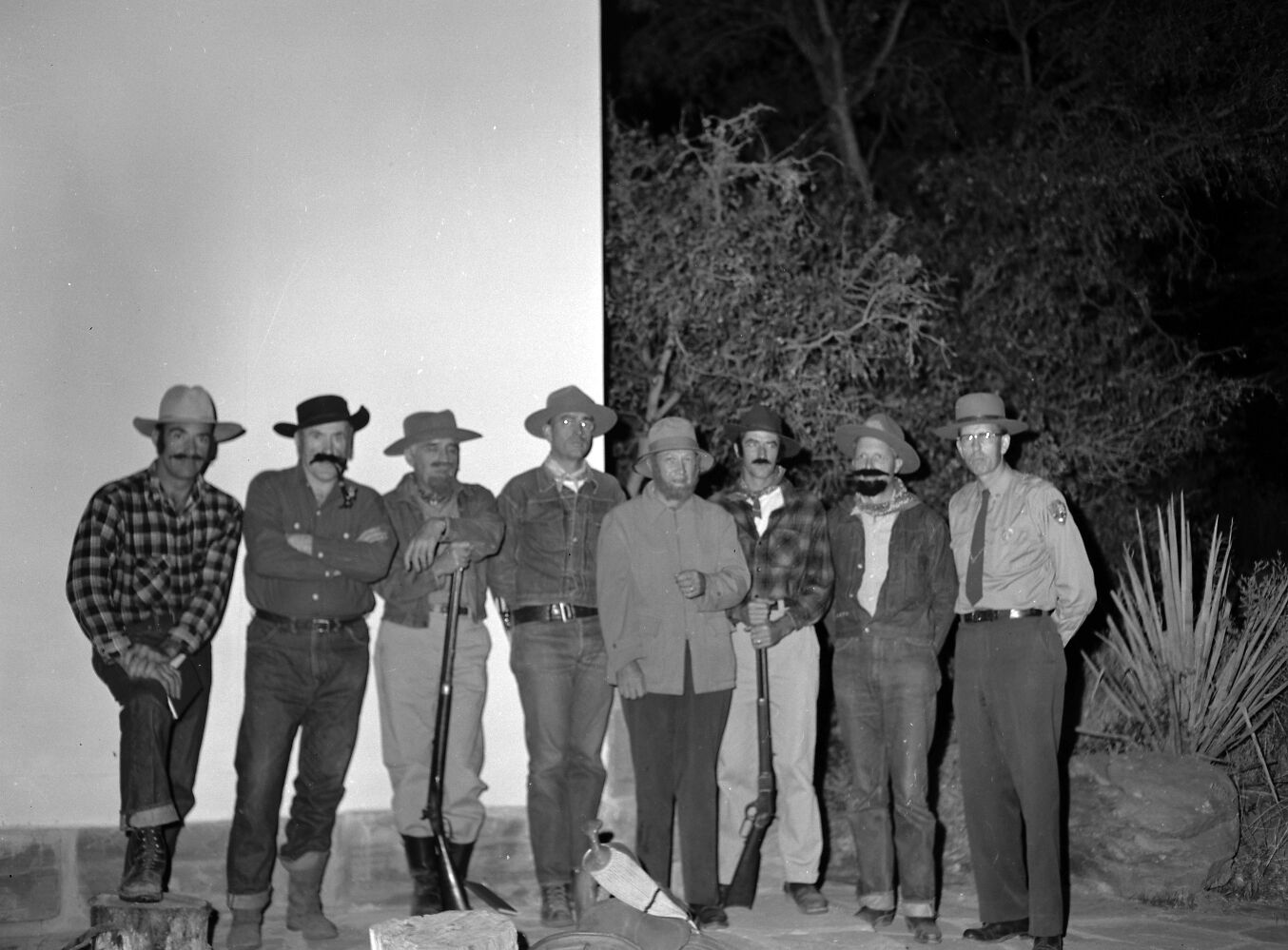 Staff in pioneer costumes and ranger in uniform posing on stage during campfire program. Campfire Day, September 19, 1957 at the South Campground amphitheater.
