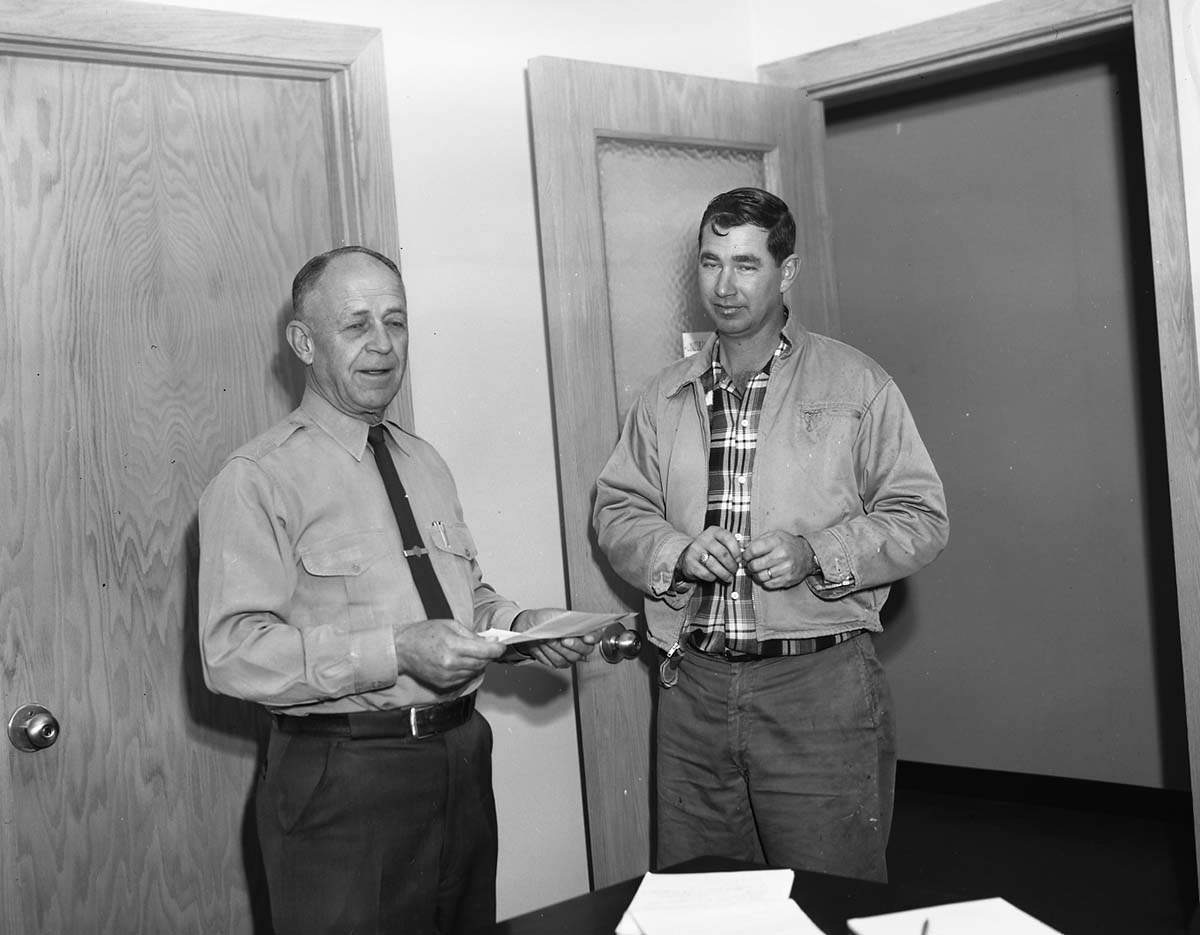 Superintendent Oberhansley presents three incentive awards to Roy O. Curbow.