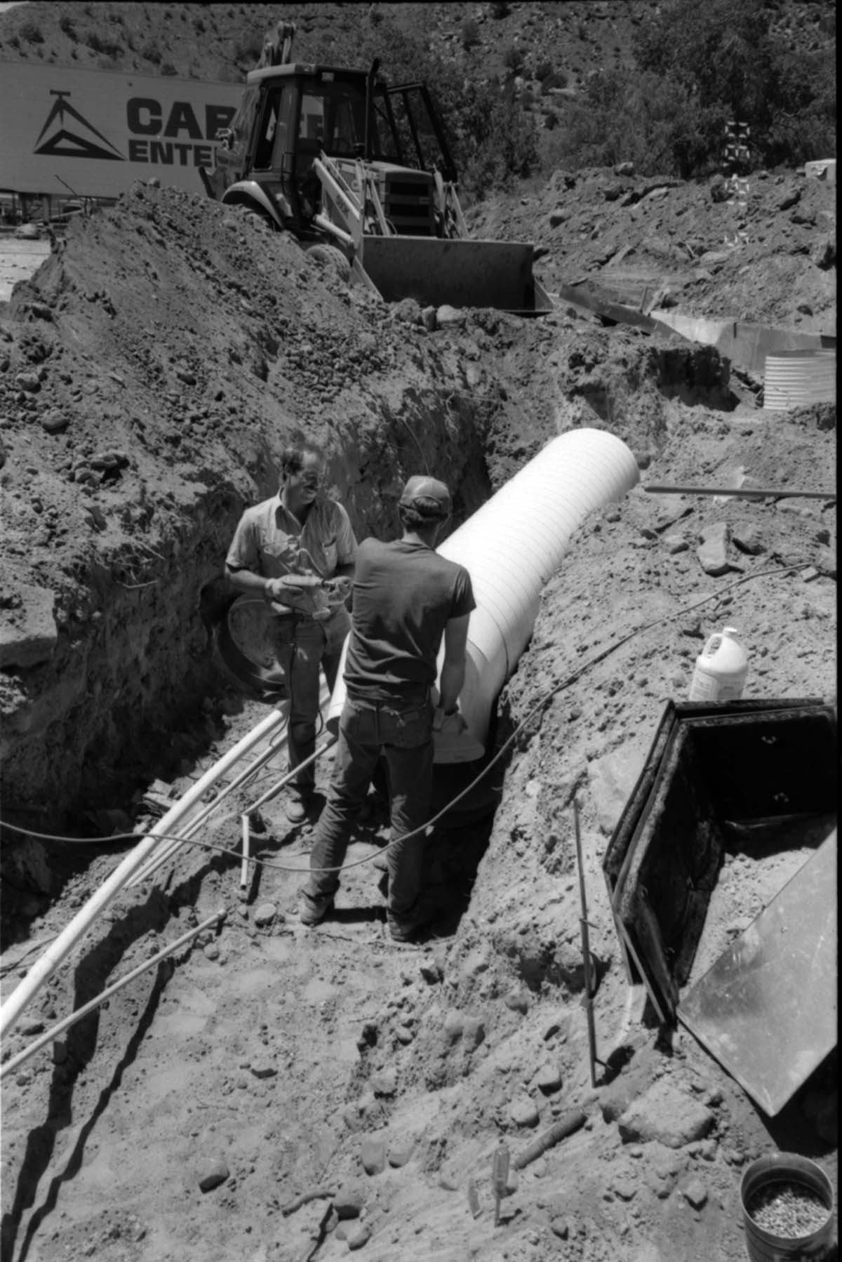 Workers laying pipe during the construction of headquarters addition.