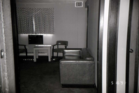 Couch and chairs in living room area of barracks. [Image possibly for comparative housing study]
