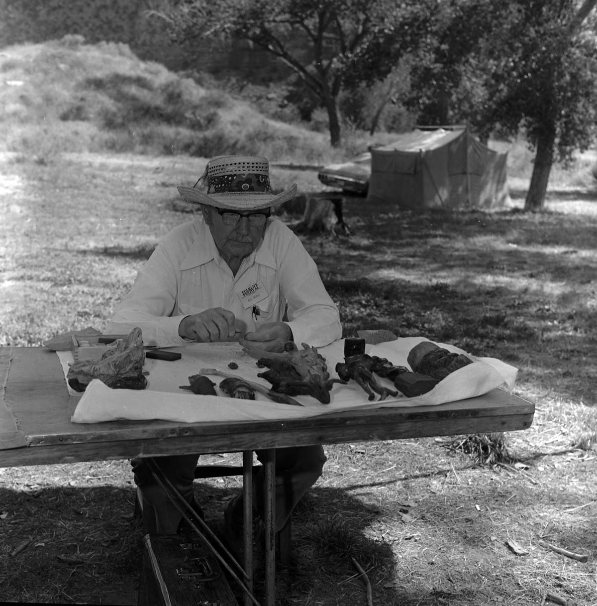 Bill Miller carving a peach pit creature at the first annual Folklife Festival, Zion National Park Nature Center, September 1977.