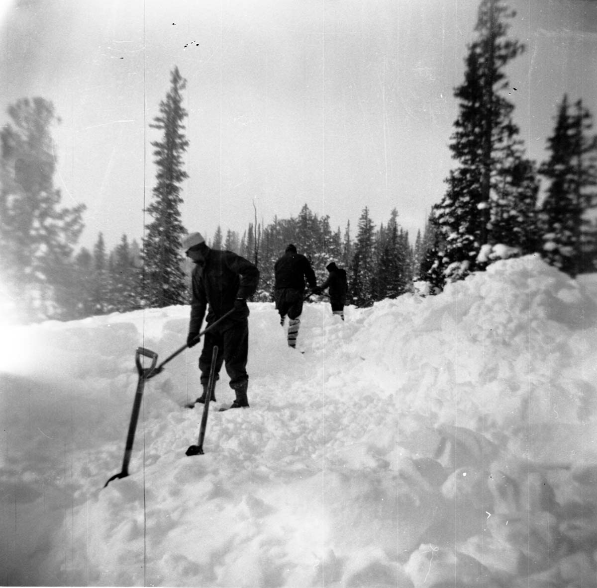 BW Photos showing rangers digging out the visitor center from snowdrift.