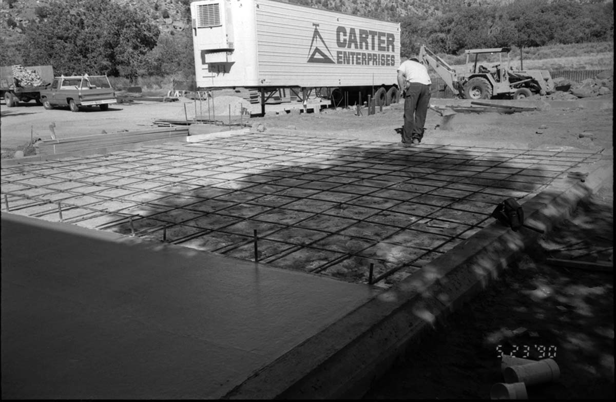Men preparing foundation for cement during construction of headquarters addition.