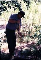 NPS employee picking up litter in campground area.