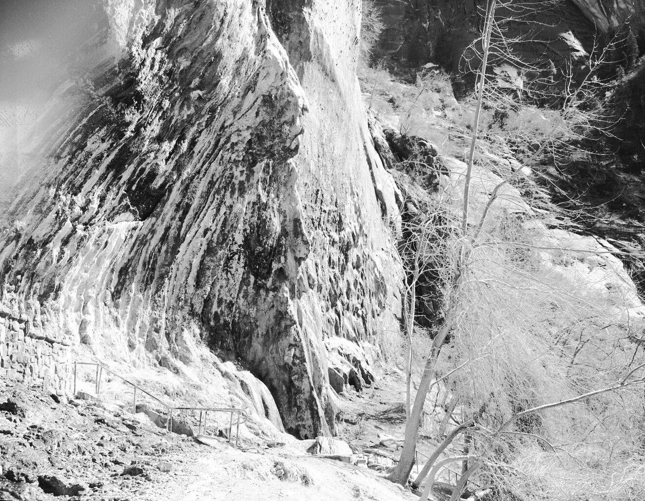 Weeping Rock. Handrail and rock wall masonry visible in foreground.
