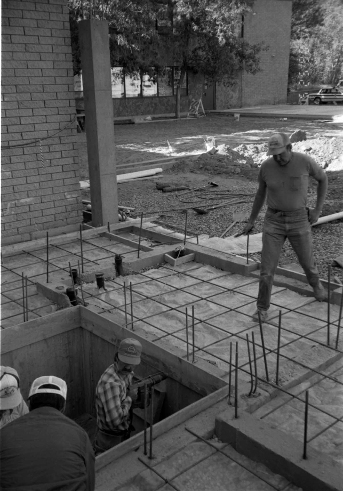 Workers performing construction duties during the construction of headquarters addition.