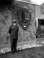 Rudy Lueck at time of retirement, next to NPS arrowhead outside Mission 66 Visitor Center and Museum and headquarters.
