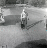 Man filling cracks in road along the scenic canyon drive near the Grotto.
