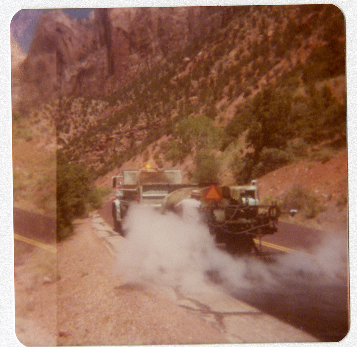 Man operating chipsealing vehicle on Zion roads.