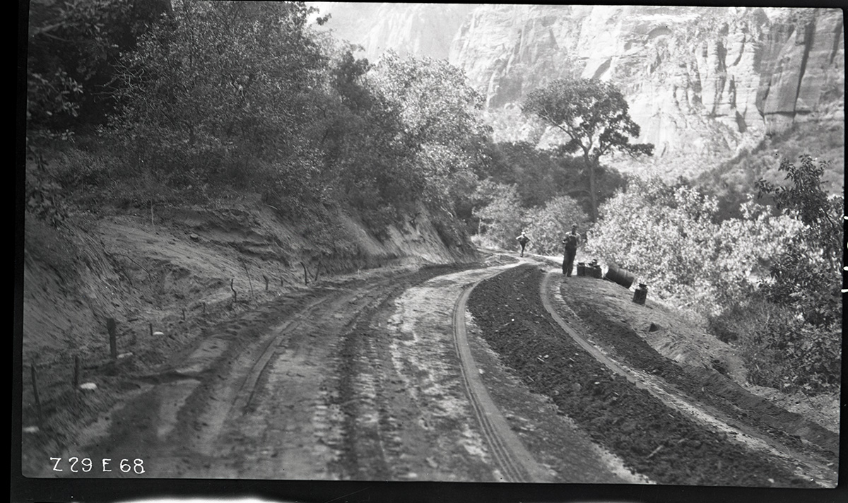 Two workers on the floor of the valley road. Labeled 'experimental road paving.'