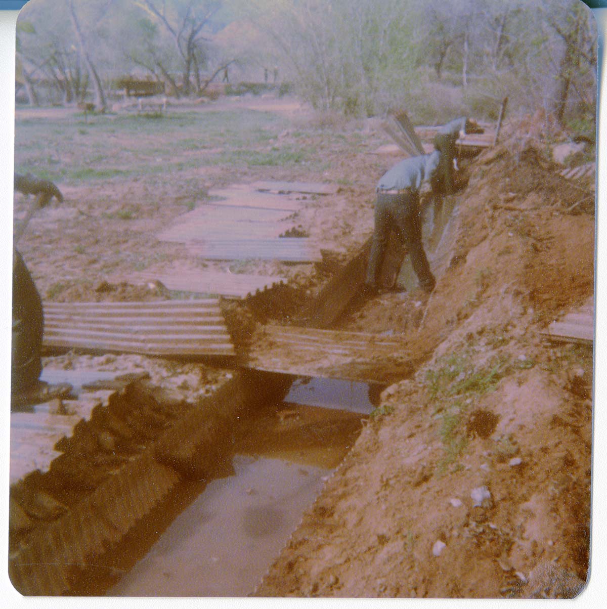 Men working to uncover the irrigation ditch in South Campground.