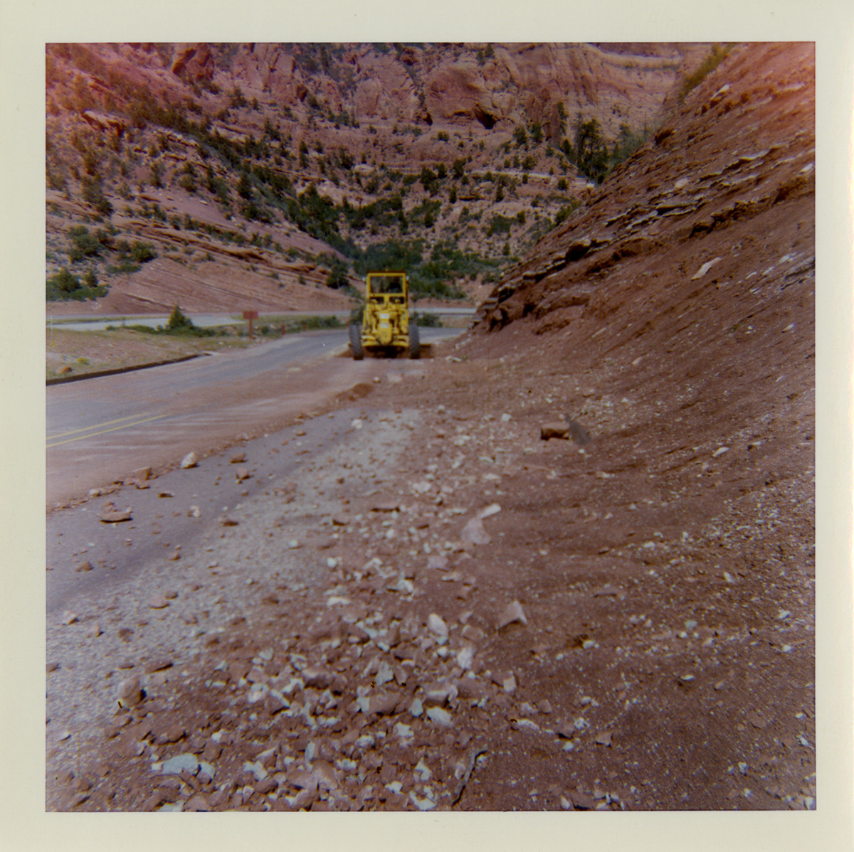 Tractor working on shoulder along Route 2 parking areas.