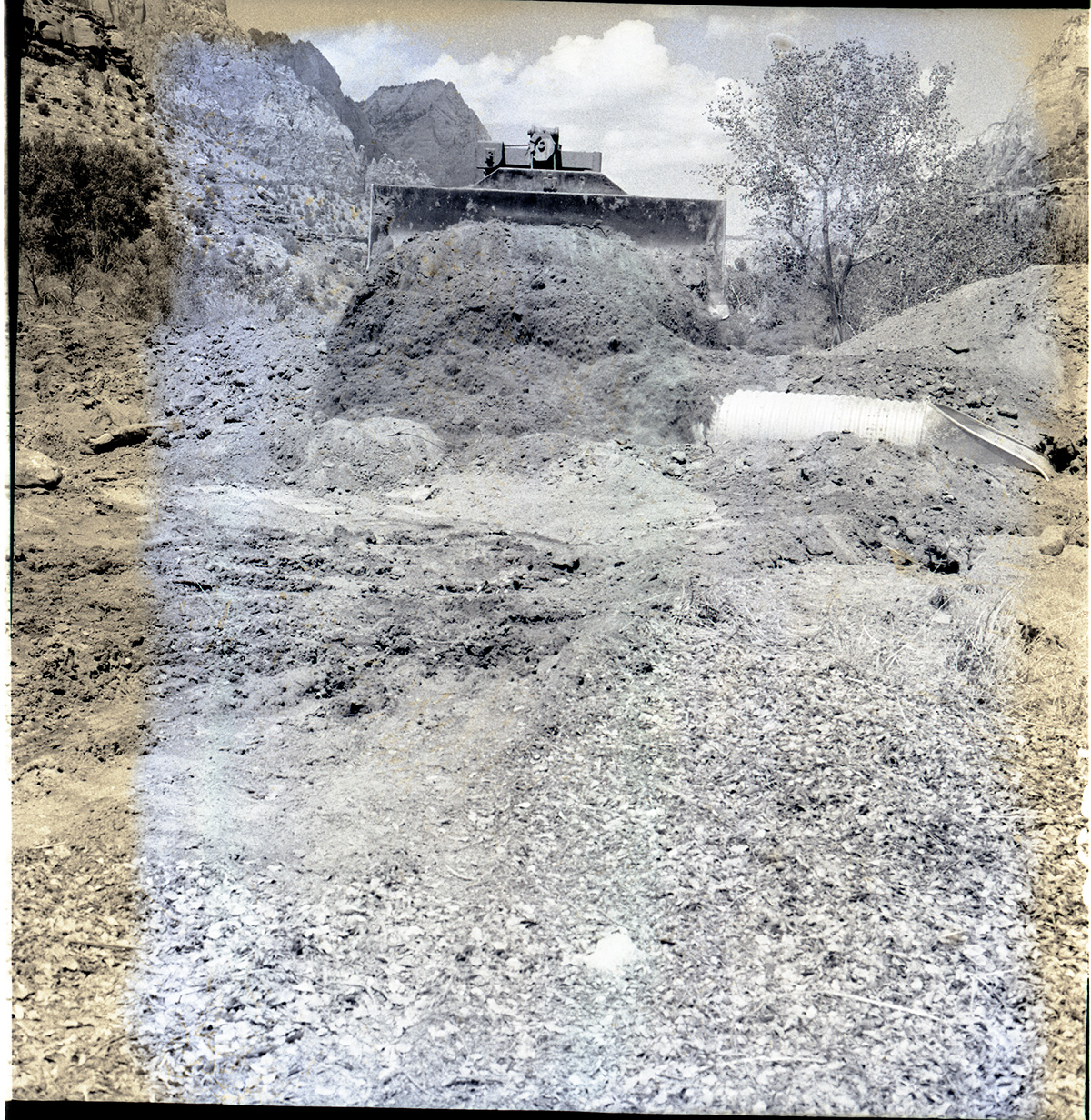Bulldozer packing new road and covering culverts for the new Highway 1 (State Route 9) from South Entrance to the Mission 66 Visitor Center and Museum.