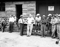 Superintendent Paul R. Franke presenting award and gift to J. Mack Bean upon disability retirement. Maintenance men seated and standing alongside at Oak Creek warehouse.