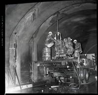 Machinery and crews drilling test cores in Zion-Mt. Carmel tunnel. Two vehicles in the tunnel.