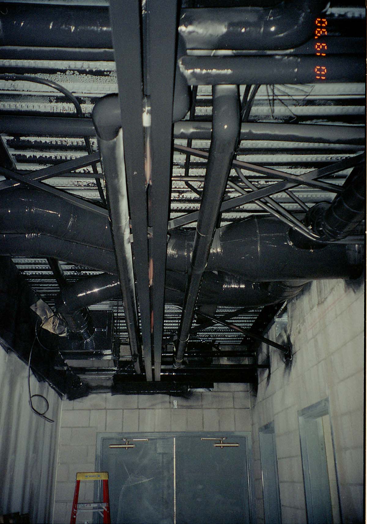 Park Headquarters Renovation: overhead pipes and exterior doors in northwest hallway, lower level.