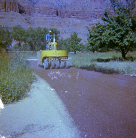 Man operating chipsealing machine to chipseal roads.