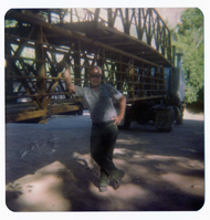 Worker leaning on bridge materials during the arrival and emplacement of three new footbridges in Zion Canyon.