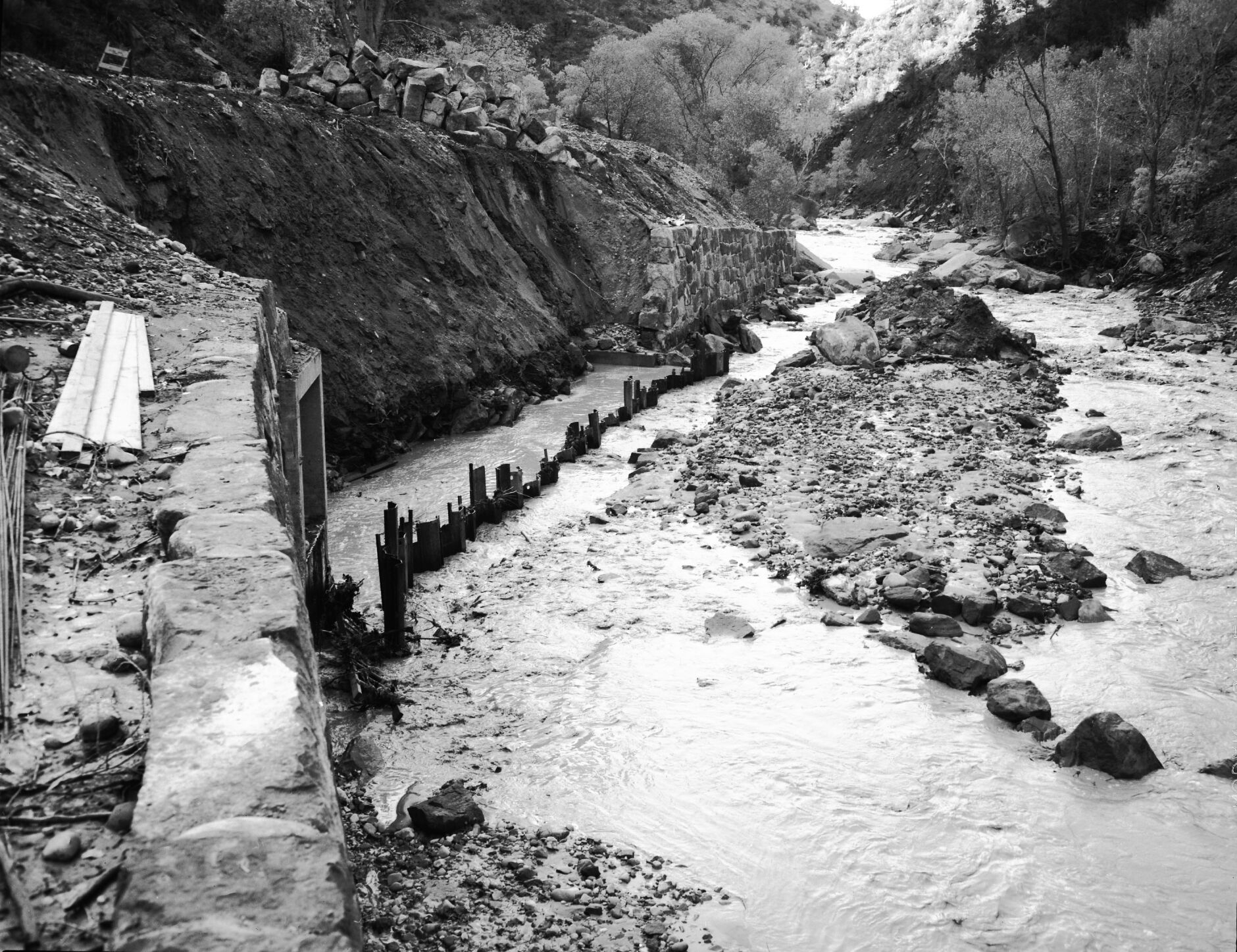 Repair of river revetment and flood damage during construction of barrier piling.