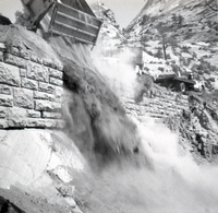 Dump truck dumping dirt during retaining wall repairs along East Rim road.