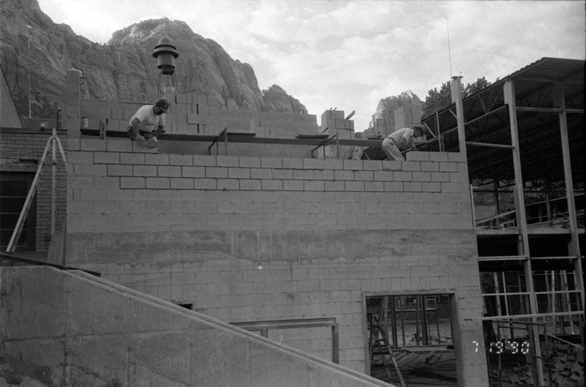 Workers placing bricks during the construction of headquarters addition.