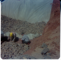 Men piling rocks on tarp during road work/repair in Kolob Canyon.