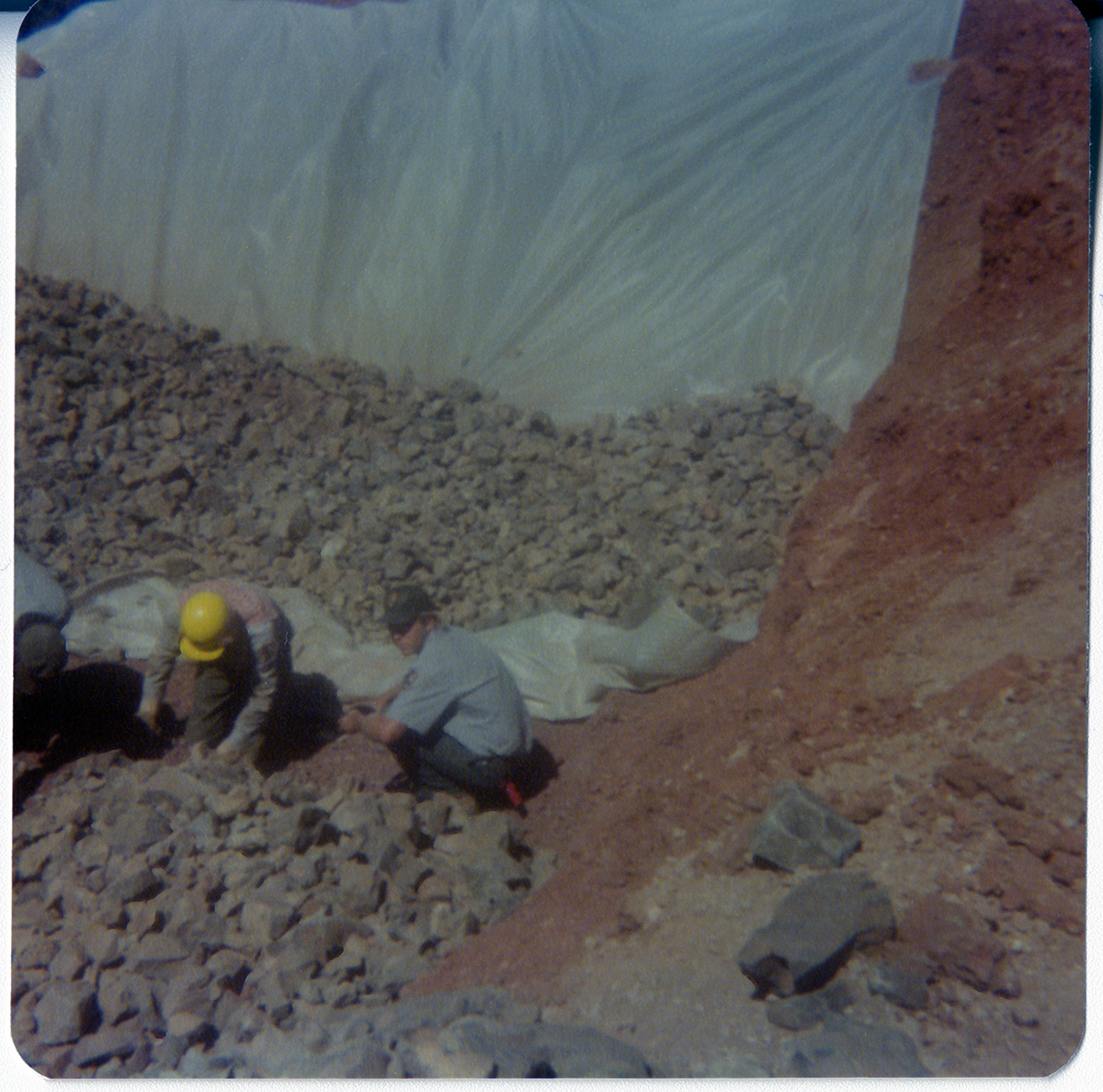 Men piling rocks on tarp during road work/repair in Kolob Canyon.