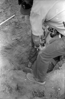 Men operating construction machinery while digging a hole during the construction of headquarters addition.