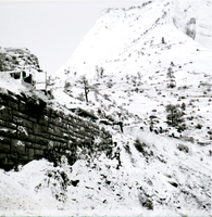 Retaining wall along East Rim road in need of repairs with line of construction vehicles.