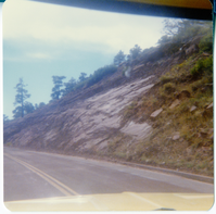 View through the windshield of the Kolob Terrace Road - North Unit and the landscape on the side of the road.