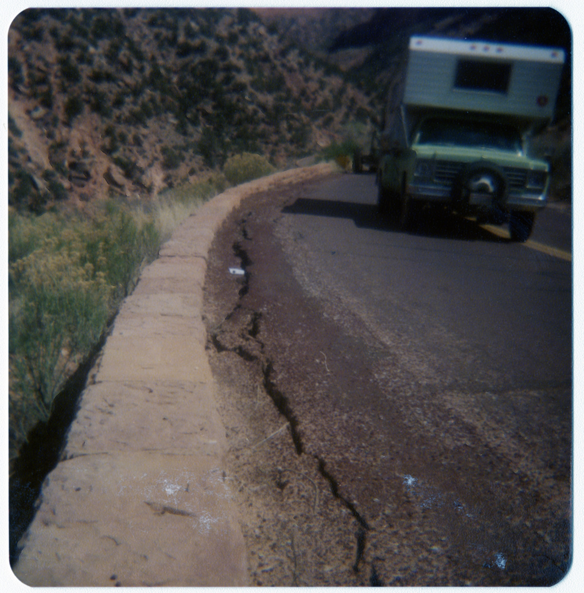 Trailer driving along road near crack in need of fixing.