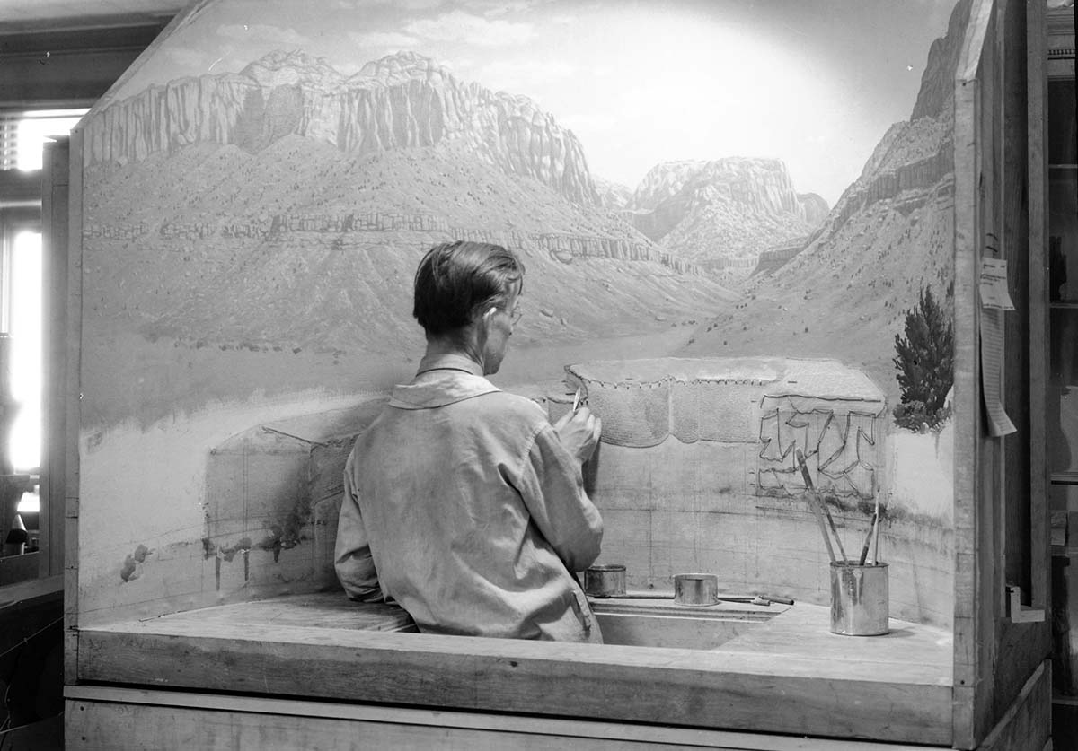 Civilian Conservation Corps (CCC) worker painting the Zion Pueblo diorama.