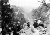 Lunchtime on Observation Point. View of horseback party seated at canyon edge on September 12, 1929. Julius R. Madsen, Union Pacific Railroad, and Walter Beatty, wrangler for Utah Parks Company (at left in cowboy hat) with a group of men and women.